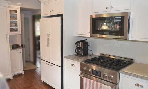 Batch Building & Remodeling: Our Promise | Remodeled kitchen with white cabinets and hardwood flooring